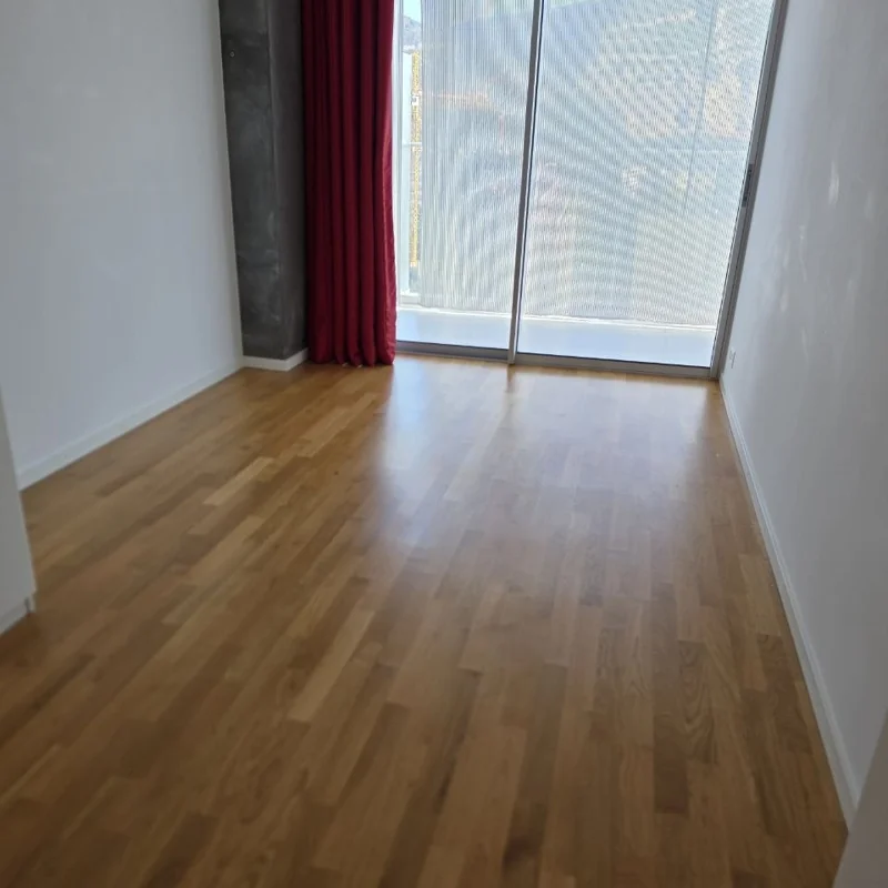 Pièce vide avec parquet et rideau rouge