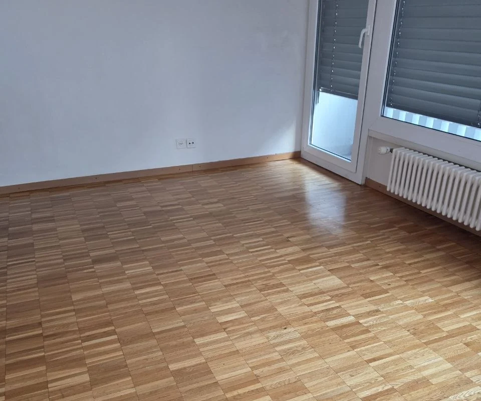 Pièce vide avec parquet et porte-fenêtre
