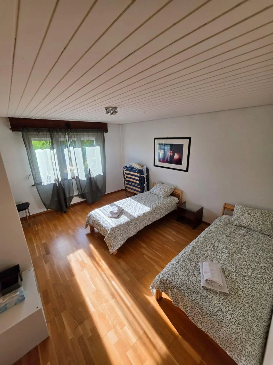 Deux lits simples avec draps et serviettes