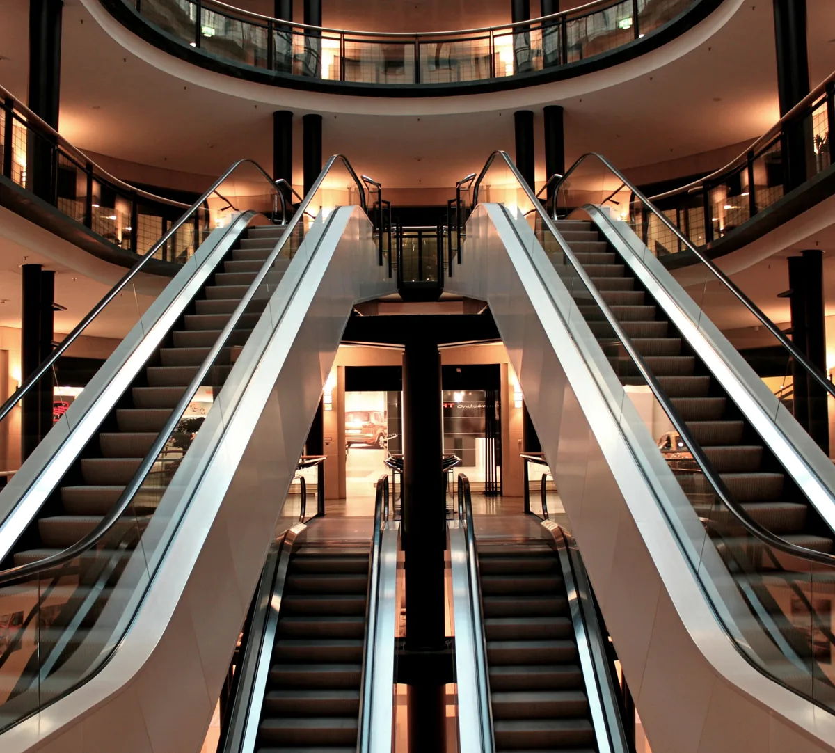 Escaliers mécaniques et galeries intérieures d’un centre commercial.
